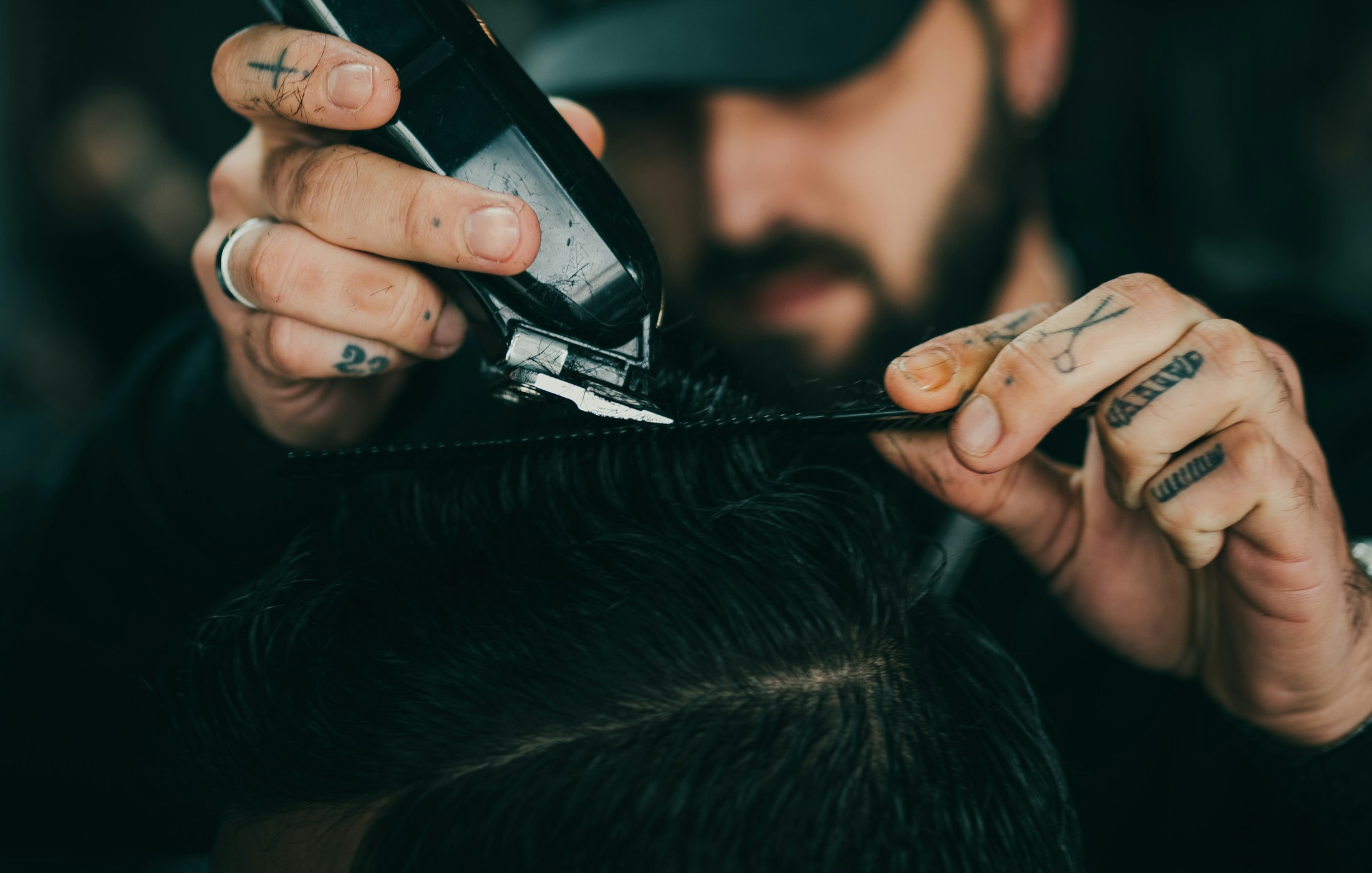 A barber carefully shaping a client's haircut